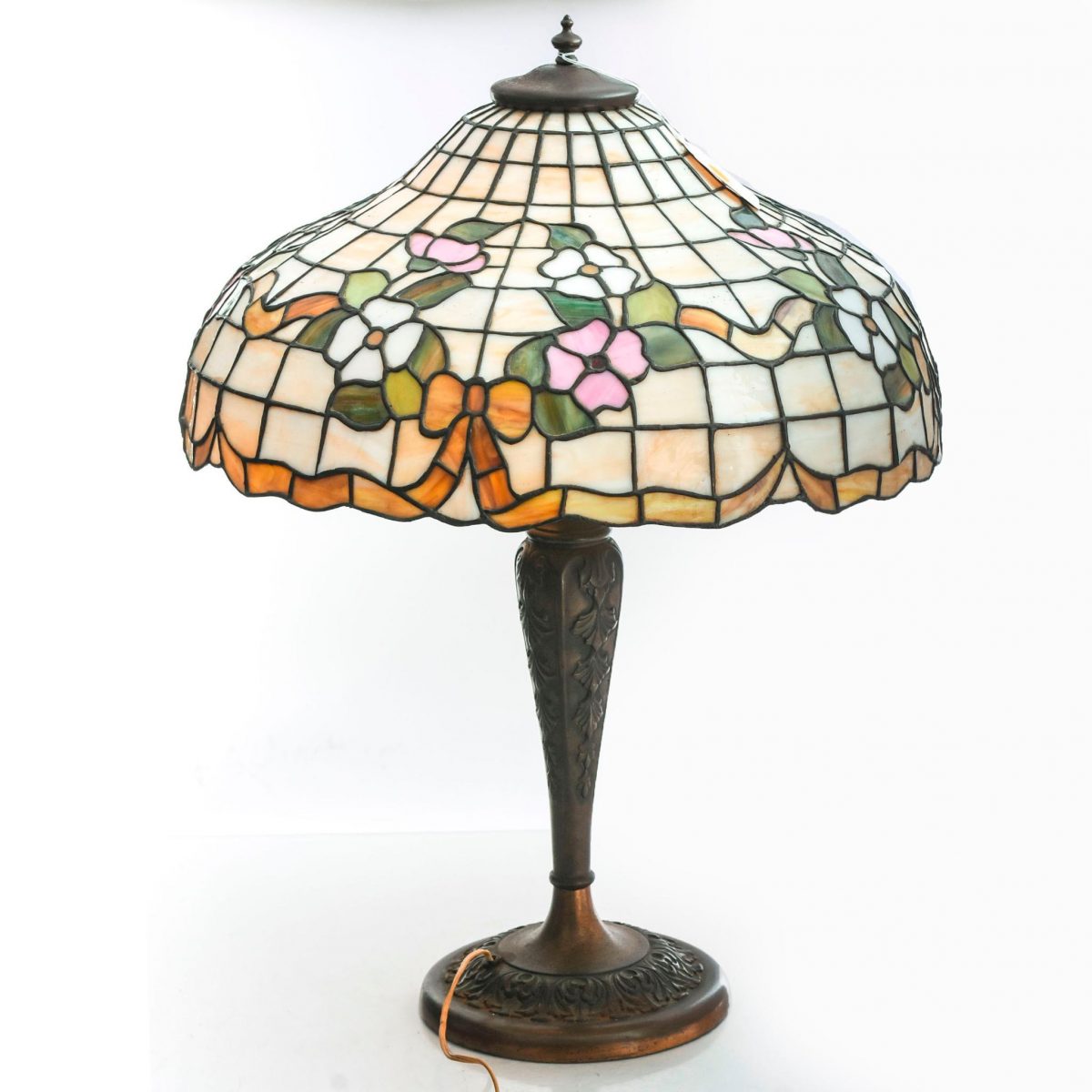 A Tiffany style lamp with bows in orange, pink, green and white colored glass.
