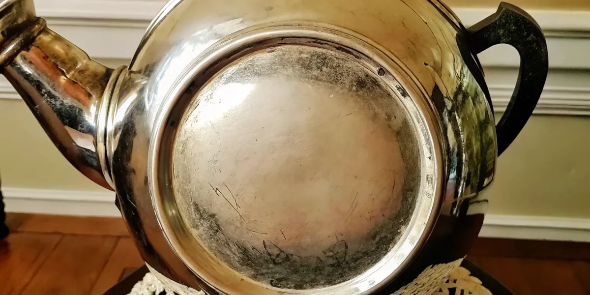 Close-up of antique silver hallmarks stamped on a silver teapot