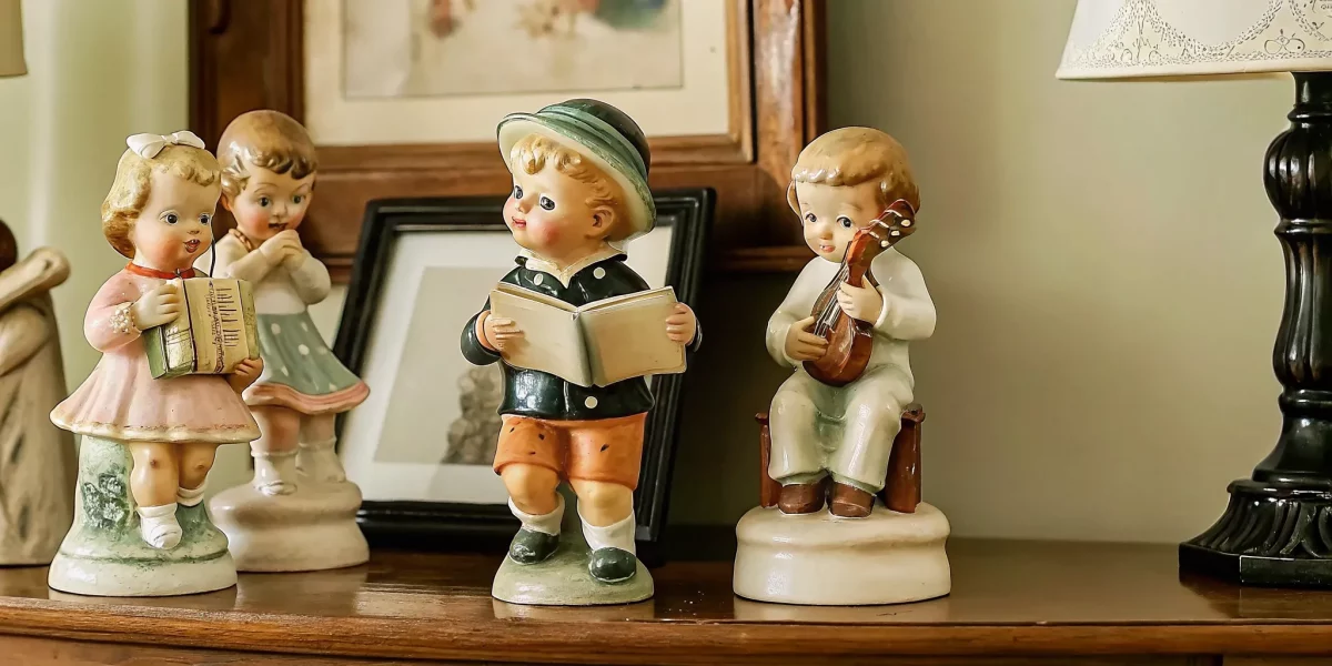 Collection of vintage Hummel porcelain figurines on a wooden shelf